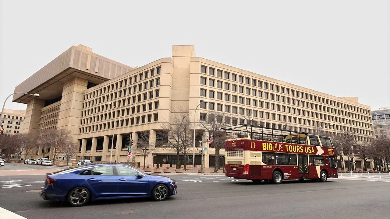 FILE PHOTO: A tour bus drives past the FBI headquarters, days after the Trump administration launched a sweeping round of cuts at the Justice Department, in Washington, U.S., February 3, 2025. REUTERS/Kevin Lamarque/File Photo