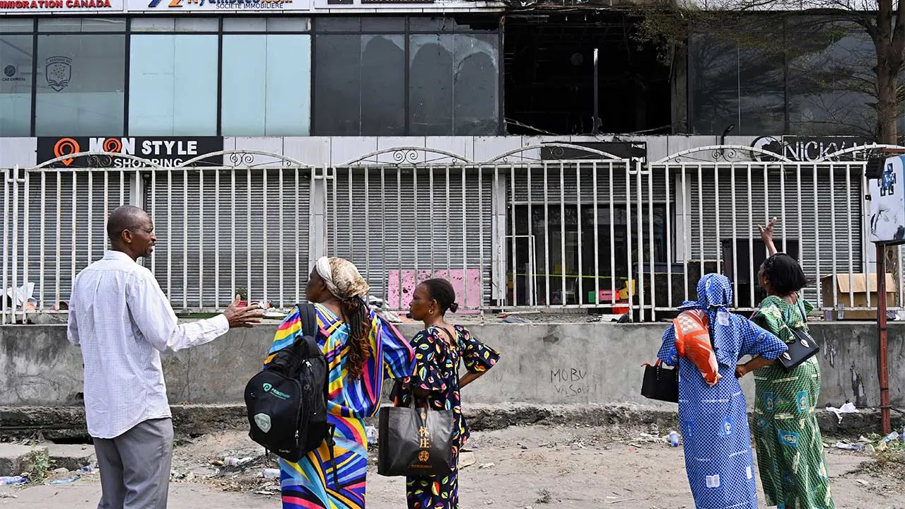 People stand outside a building damaged by a fire that killed and injured multiple people at a wedding in Lingwala, Kinshasa, Democratic Republic of Congo, September 6, 2026. REUTERS/Arsene Mpiana