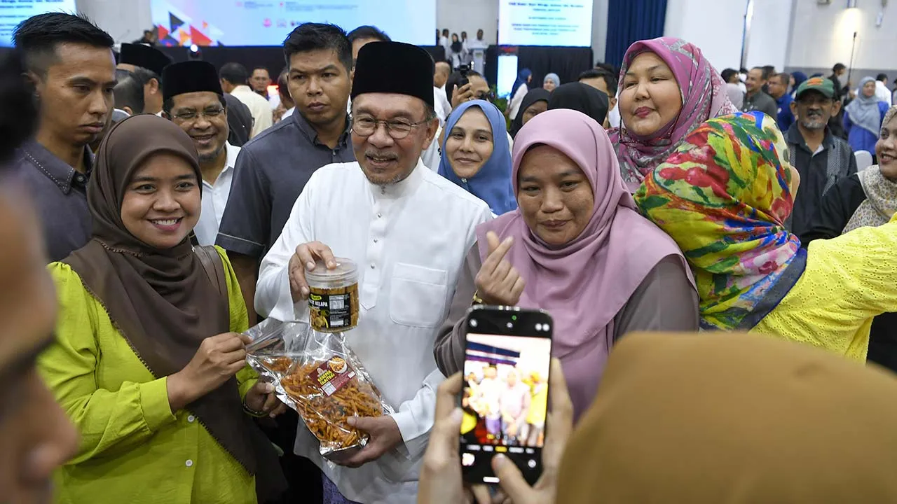 ALOR SETAR, 25 Sept - Perdana Menteri Datuk Seri Anwar Ibrahim beramah mesra bersama para penjaja sambil menerima kuih-muih pada Program Usahawan Bangkit MADANI peringkat Negeri Kedah di Dewan Kompleks Persekutuan Muadzam Shah di sini hari ini. - fotoBERNAMA (2026) HAK CIPTA TERPELIHARA *** Local Caption ***