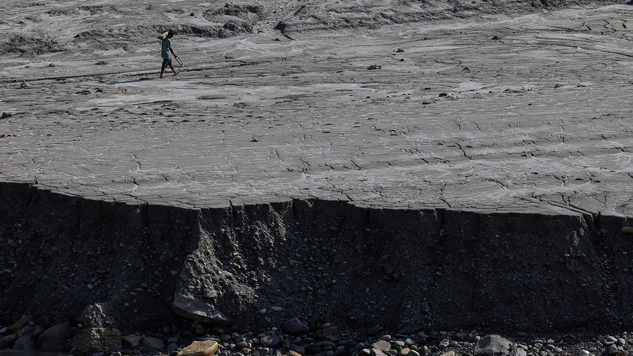A man walks along a mud-covered riverbank following deadly flash floods and mudslides, in Dhading district, Nepal, September 14, 2026. REUTERS/Tyrone Siu TPX IMAGES OF THE DAY