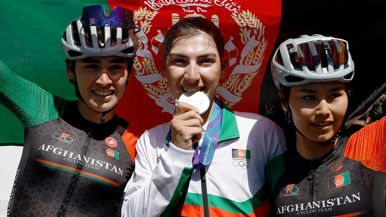 Asian Games - Aichi-Nagoya 2026 - Road Cycling - Women's Road Race - Final - Shinshiro Cycling Road Course, Shinshiro, Japan - September 22, 2026 Silver medallist Afghanistan's Fariba Hashimi celebrates with teammates Yuldoz Hashimi and Zahra Rezayee during the victory ceremony REUTERS/Bryan Foo