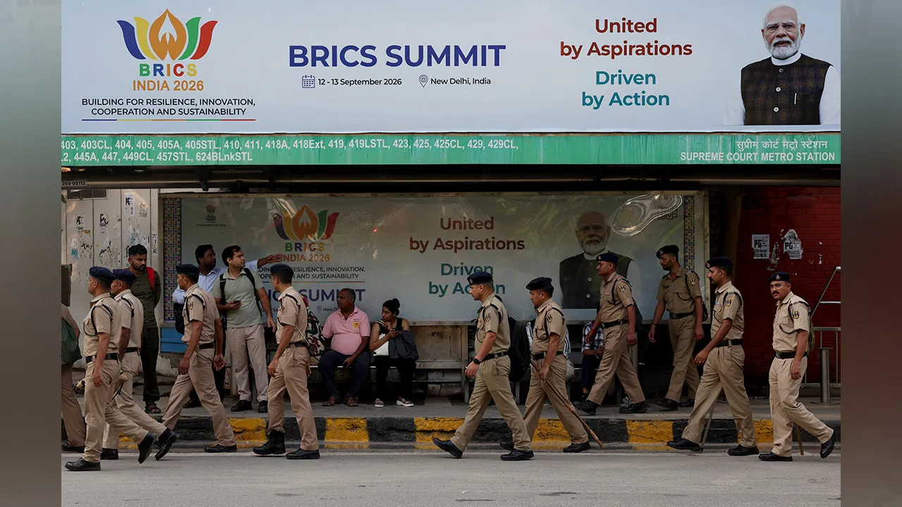Police personnel move past a hoarding featuring India's Prime Minister Narendra Modi displayed near Bharat Mandapam, ahead of the upcoming BRICS Summit in New Delhi, India, September 8, 2026. REUTERS/Bhawika Chhabra