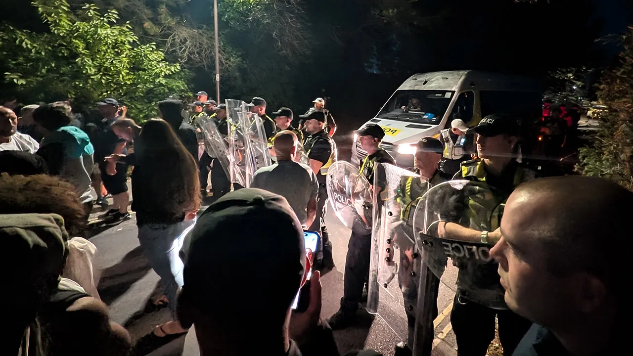 Police officers form a line to block protesters near Eastney Beach, in Portsmouth, England, Sunday, Sept. 6, 2026. (PA via AP)