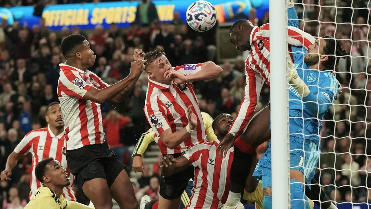 Arsenal's goalkeeper David Raya, right, makes a save in front of Sunderland's Nordi Mukiele during the English Premier League soccer match between Sunderland and Arsenal in Sunderland, England, Saturday, Sept. 12, 2026. (AP Photo/Ian Hodgson)
