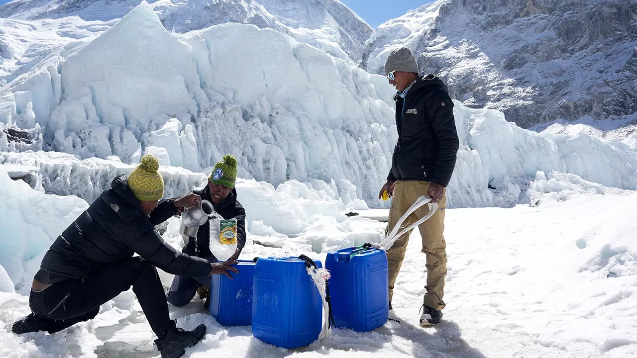 FILE PHOTO: People collect water from a glacier at Everest base camp, Nepal April 13, 2025. REUTERS/Purnima Shrestha/File Photo