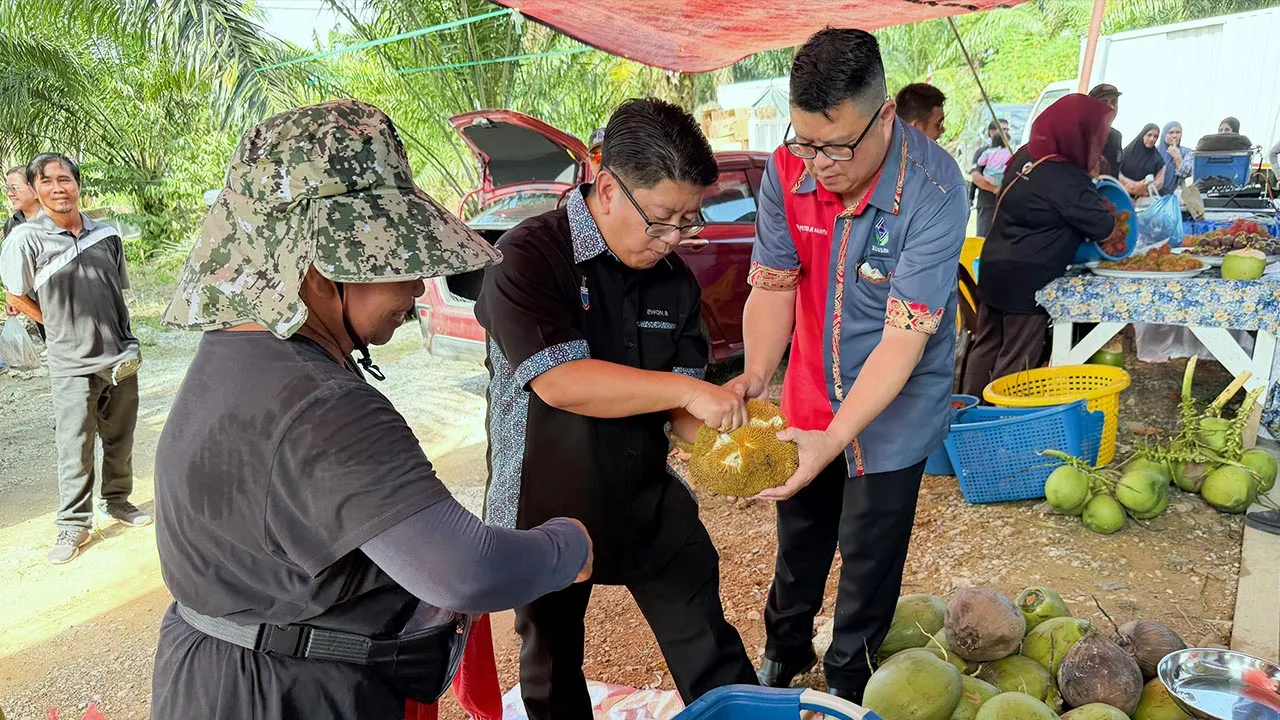 SANDAKAN, 18 Sept - Timbalan Ketua Menteri merangkap Menteri Perindustrian, Keusahawanan dan Pengangkutan Sabah Datuk Ewon Benedick (tengah) mencuba buah tarap ketika melawat gerai jualan sebelum merasmikan Premis Tamu Desa Kampung Ulu Dusun sempena program Usahawan Tempatan Sabah First hari ini. Turut hadir Pengerusi Koperasi Usahawan Libaran Sabah Berhad (KOULIS) Dr Peter Jr Naintin (kanan). - fotoBERNAMA (2026) HAK CIPTA TERPELIHARA