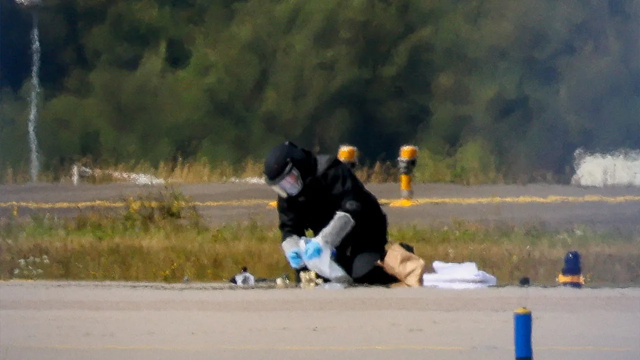 FILE PHOTO: A police officer in protective clothing works at Leipzig/Halle Airport in Schkeuditz, Germany, August 5, 2026, after the police said explosives experts examined a drone near a runway, and after a DHL cargo aircraft hit an unknown object as it was climbing away from the airport overnight, prompting an unscheduled landing in Hanover, according to a source familiar with the incident. REUTERS/Axel Schmidt/File Photo