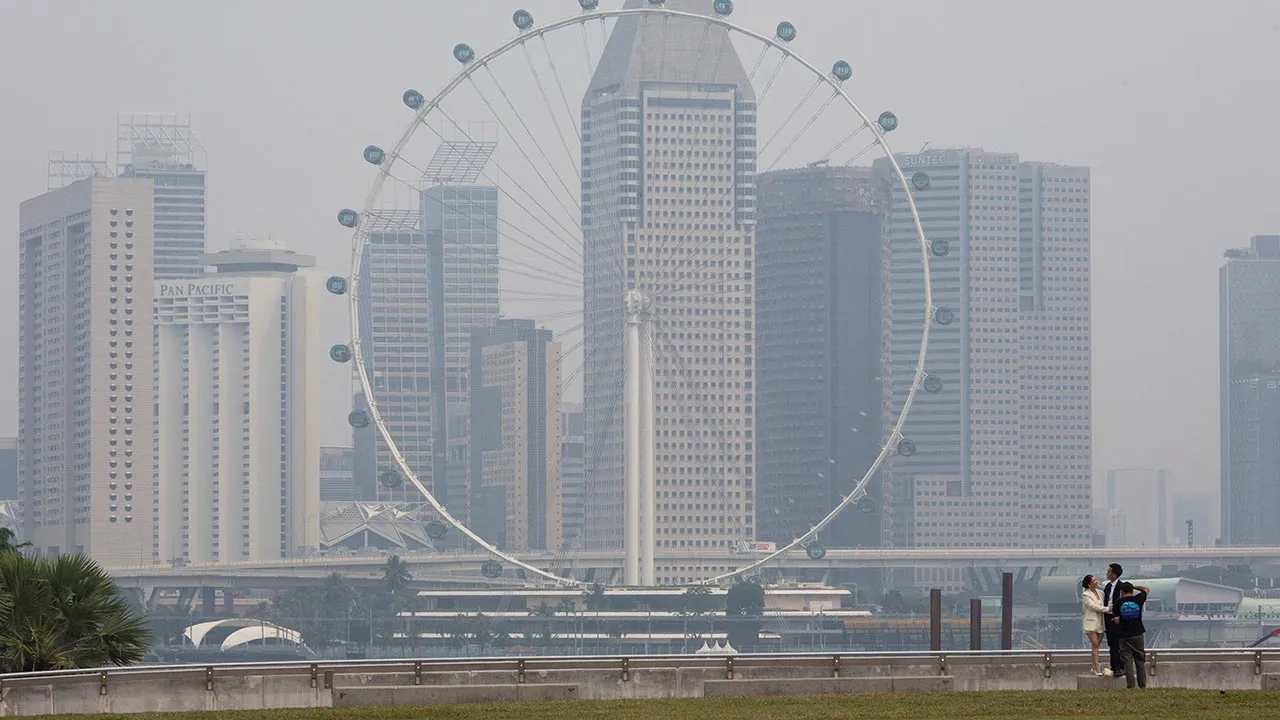 The Singapore Flyer and commercial buildings are shrouded in haze at the Marina Bay area in Singapore, September 15, 2026. REUTERS/Ore Huiying