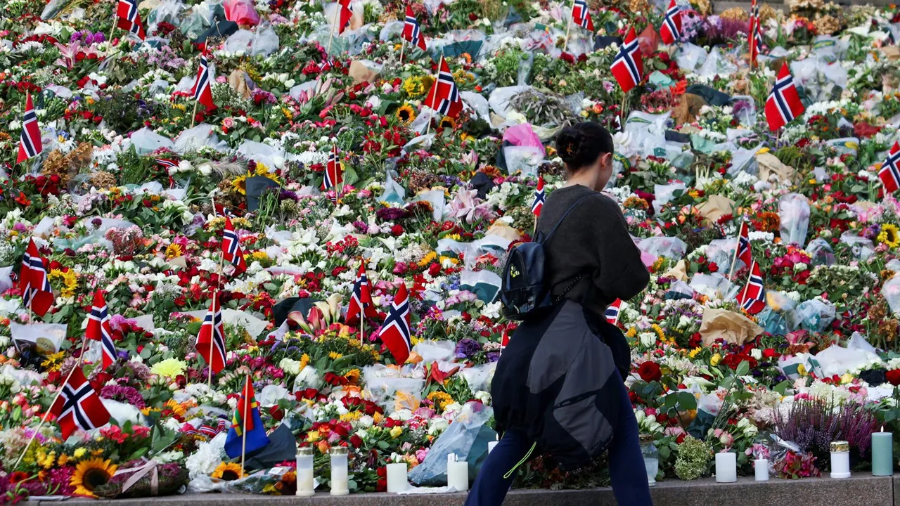A woman walks past floral tributes on the day of the funeral of Norway's King Harald, outside the royal palace in Oslo, Norway, September 9, 2026. REUTERS/Claudia Greco