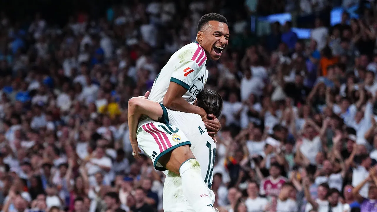 Real Madrid's Alvaro Carreras, bottom, is congratulated by Kylian Mbappe after scoring his side's 2nd goal during the Spanish La Liga soccer match between Real Madrid and Rayo Vallecano in Madrid, Spain, Saturday, Sept. 12, 2026. (AP Photo/Manu Fernandez)
