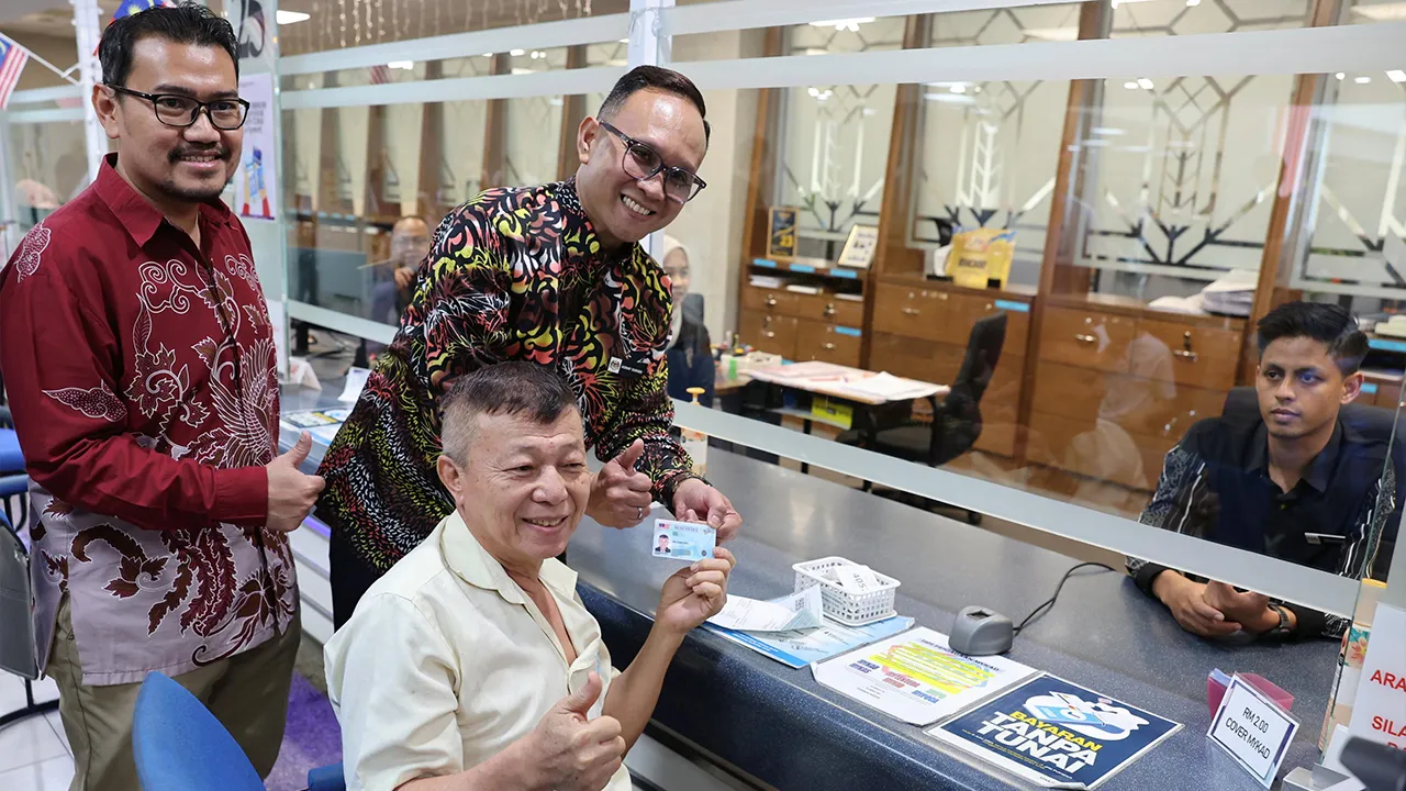 PUTRAJAYA, 17 Sept - Pengarah Bahagian Kad Pengenalan Jabatan Pendaftaran Negara (JPN) Muhammad Asraf Sukadi (berdiri dua, kiri) menyantuni orang ramai pada hari pertama pengeluaran MyKad Generasi Baharu di JPN hari ini. - fotoBERNAMA (2026) HAK CIPTA TERPELIHARA