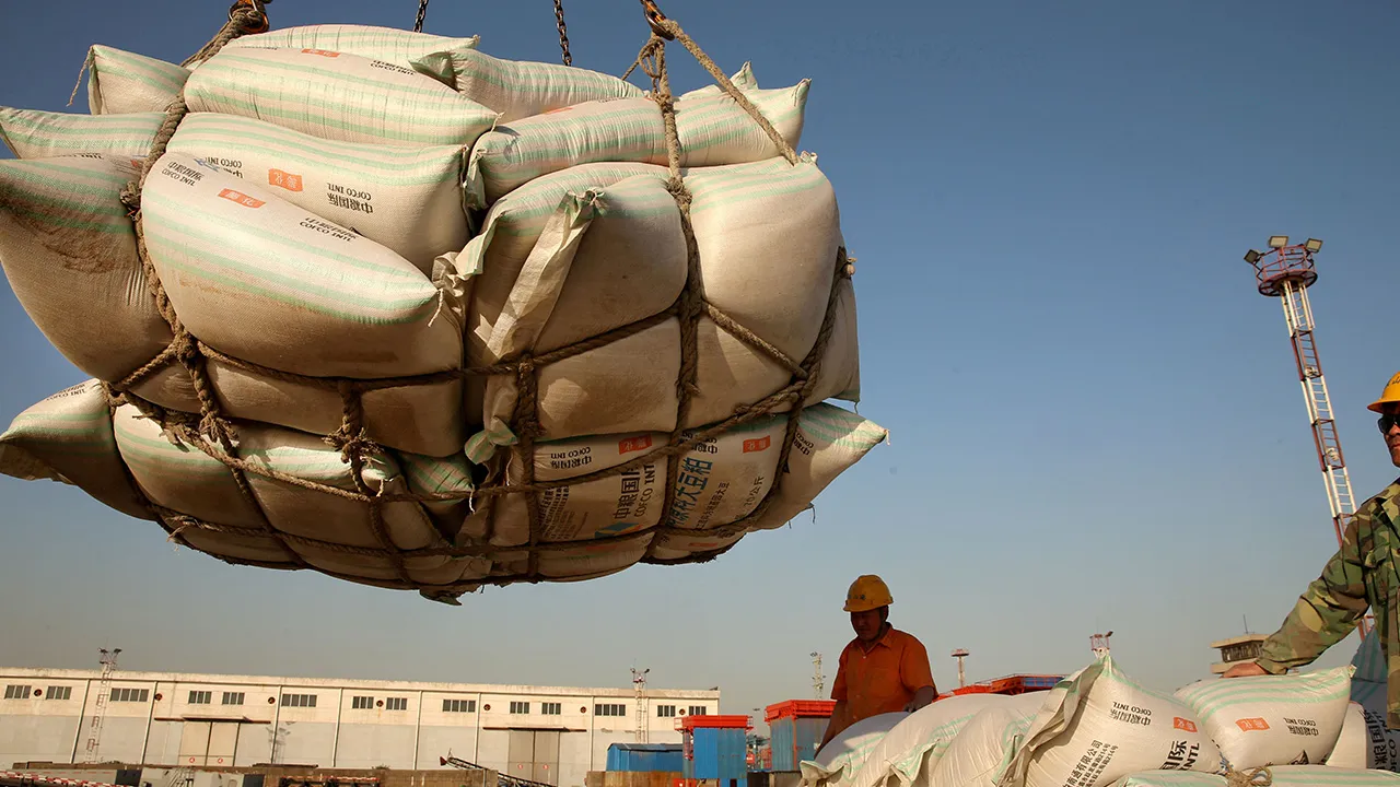 Workers transport imported soybean products at a port in Nantong, Jiangsu province, China April 9, 2018. REUTERS