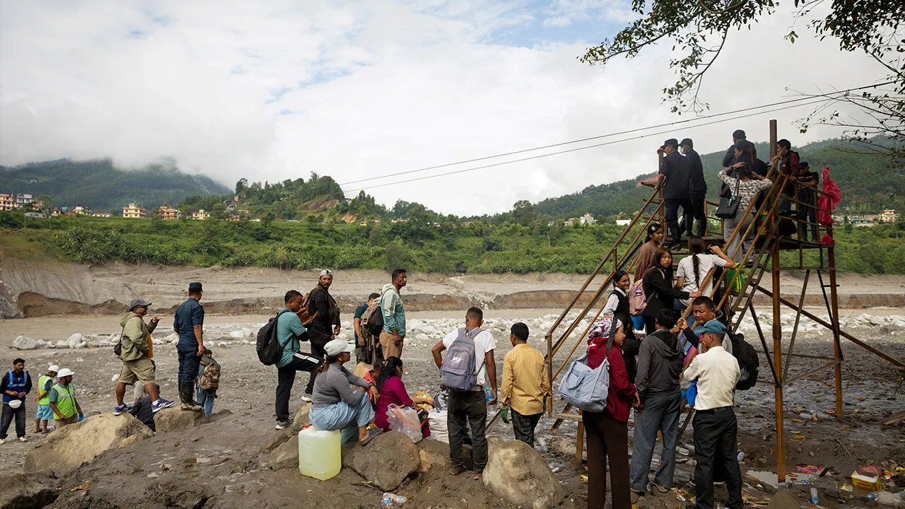 People stand in a queue as they wait to ride on a cage on a makeshift zip line to cross the Trishuli River from Koloni following deadly flash floods that damaged bridges and temporarily stranded residents, in Nuwakot district, Nepal, September 4, 2026. REUTERS/Adnan Abidi
