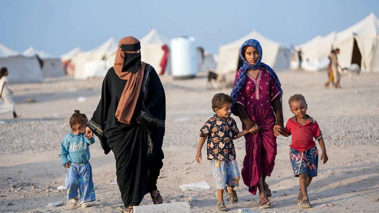 Women and children, who fled fighting between the Houthis and government forces in Red Sea coastline areas, walk at a camp for internally displaced people near Aden, Yemen, September 19, 2026. REUTERS/Stringer TPX IMAGES OF THE DAY/File Photo