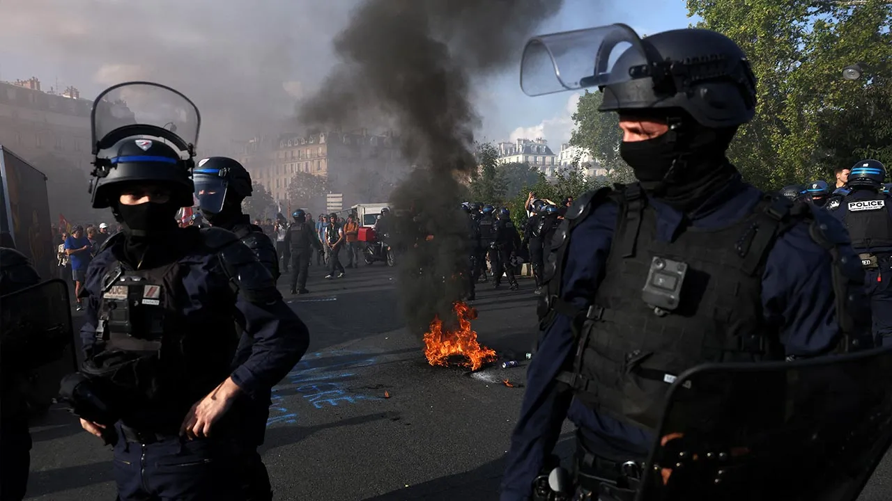 French police stand next to a burning tyre during a demonstration by French firefighters on strike calling for more resources and funding following a summer marked by mega-fires, in Paris as part of a day of strikes and protests by public sector workers in France, September 29, 2026. REUTERS/Tom Nicholson