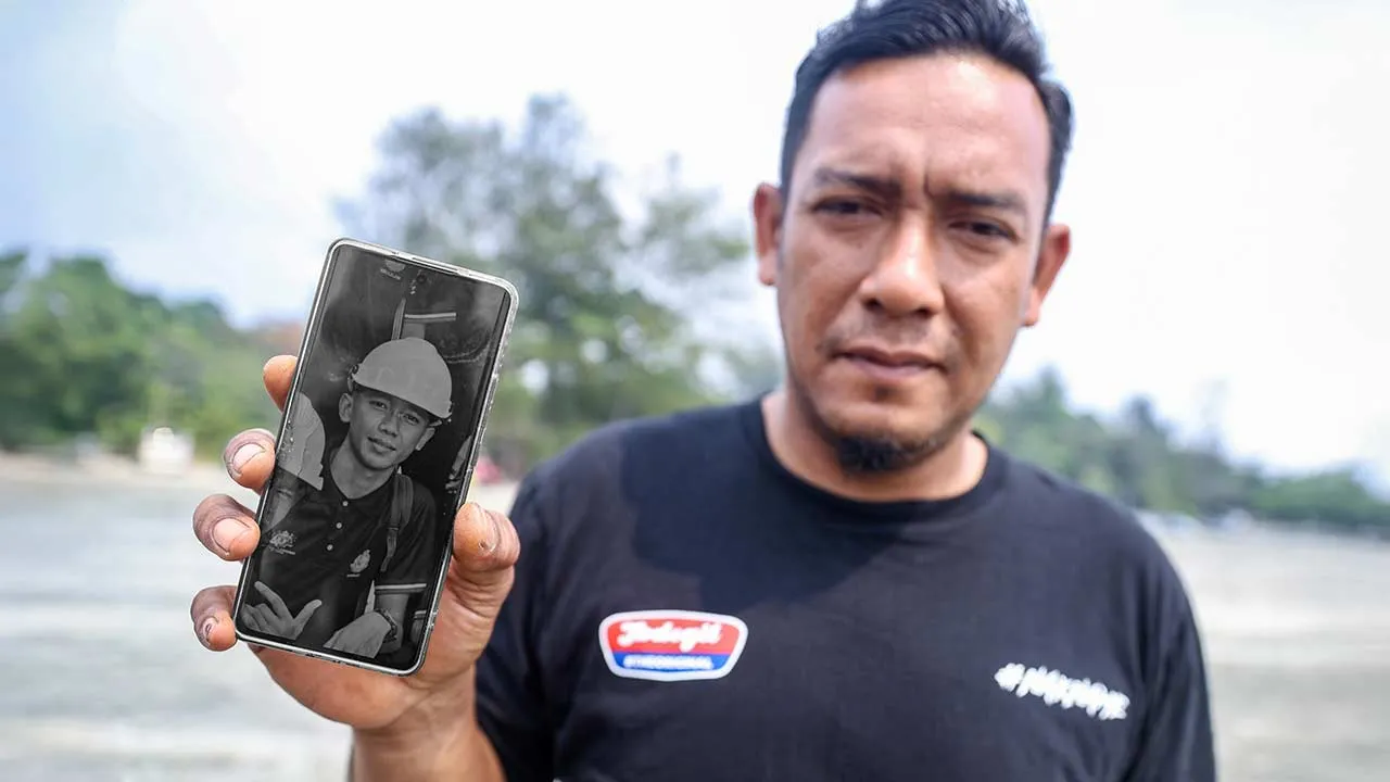 KOTA TINGGI, 4 Sept - Waris, Shahrizal Ibrahim, 41, menunjukkan gambar Mohamad Haiman Fitri Supian, salah seorang daripada dua mangsa yang masih hilang dalam operasi mencari dan menyelamat (SAR) di Pantai Tanjung Lompat, hari ini. - fotoBERNAMA (2026) HAK CIPTA TERPELIHARA