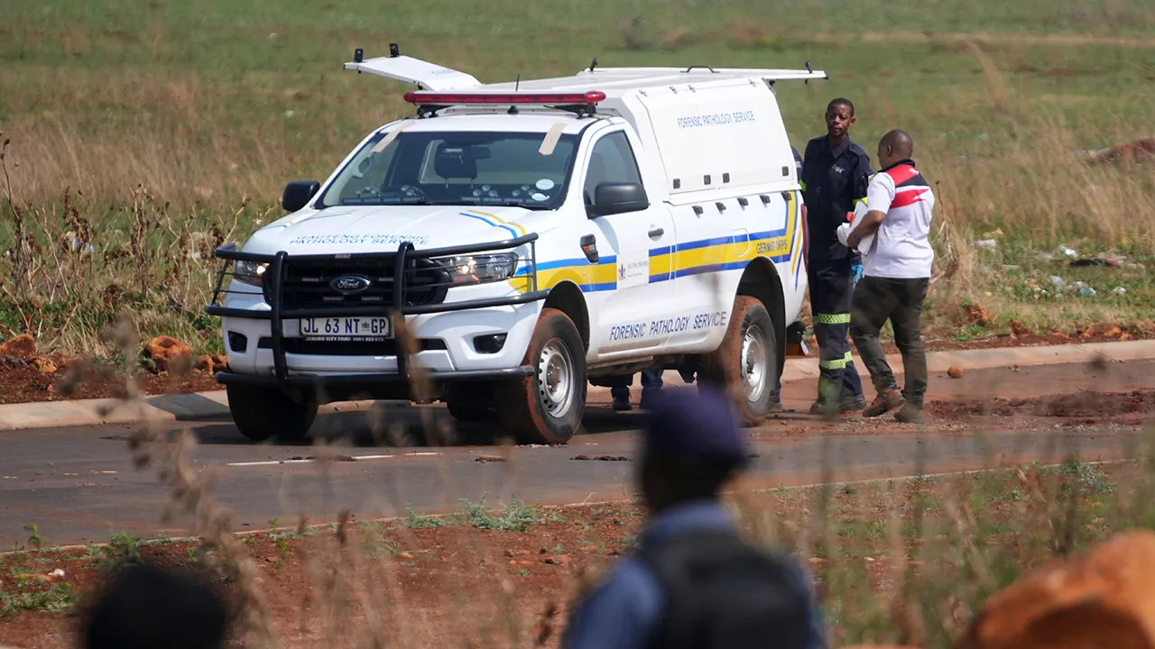Forensic investigators work at the site where the body of a woman was discovered on the outskirts of Johannesburg, South Africa, Thursday, Sept. 17, 2026. (AP Photo/Themba Hadebe)