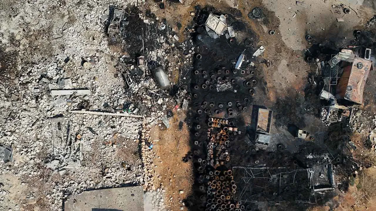 Collapsed structures, burned vehicles and scorched vehicle parts are seen at the site of an explosion at what Syria's Defense Ministry said was a warehouse used to store weapons and munitions near Sarmada, in Idlib province, Syria, Wednesday, Sept. 9, 2026. (AP Photo/Omar Albam)