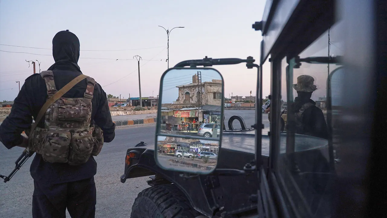Soldiers formerly with the Kurdish-led Syrian Democratic Forces stand guard in Hasakah, northeastern Syria, Wednesday, Aug. 26, 2026. The force announced its dissolution Tuesday after completing its merger with the Syrian army. (AP Photo/Baderkhan Ahmad) ADDITION: Adds that the SDF announced its dissolution Tuesday after completing its merger with the Syrian army.