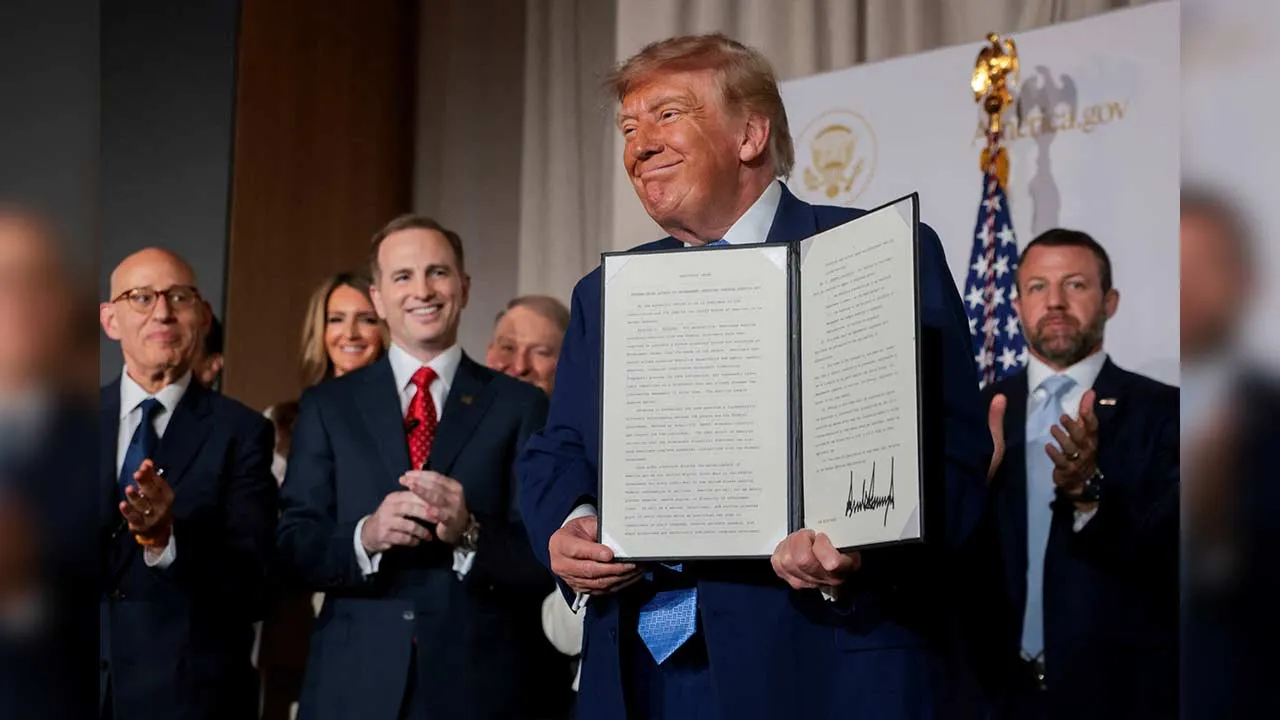 US President Donald Trump shows a signed Executive Order related to a new AI-powered government website, America.gov, during the website's National Design Studio launch event at the Mellon Auditorium in Washington, D.C., US, September 29, 2026. REUTERS/Jonathan Ernst
