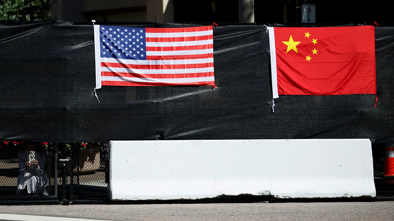 A US flag and a Chinese flag are displayed on a security barrier, on the day of an official visit by Chinese President Xi Jinping and his wife, Peng Liyuan, to the White House in Washington, DC, US, September 25, 2026. REUTERS/