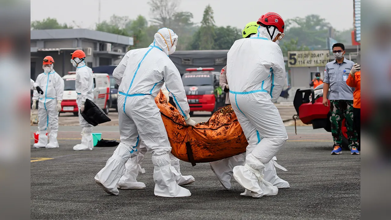 Rescuers in protective suits carry a body bag of a victim recovered from the Virgo Transport 8 ferry, which capsized in the Java Sea while sailing from Surabaya in East Java to Banjarmasin in South Kalimantan, to be transported to hospital for identification, upon arrival at Sjamsudin Noor airbase in Banjarbaru, South Kalimantan province, Indonesia, September 24, 2026. REUTERS/Abdulrahman Muda Sagala