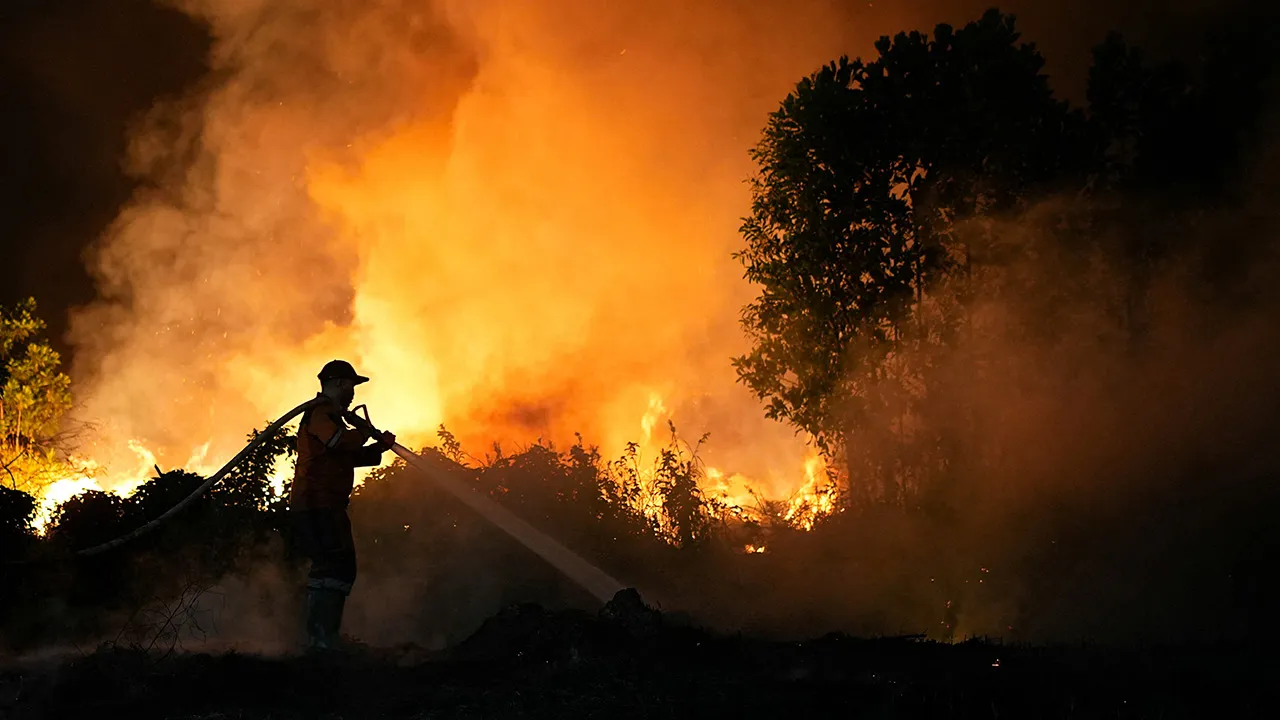 A firefighter sprays water in an attempt to extinguish a wildfire near the Palembang-Indralaya toll road in Ogan Ilir, South Sumatra province, Indonesia, August 28, 2026. REUTERS/Abriansyah Liberto