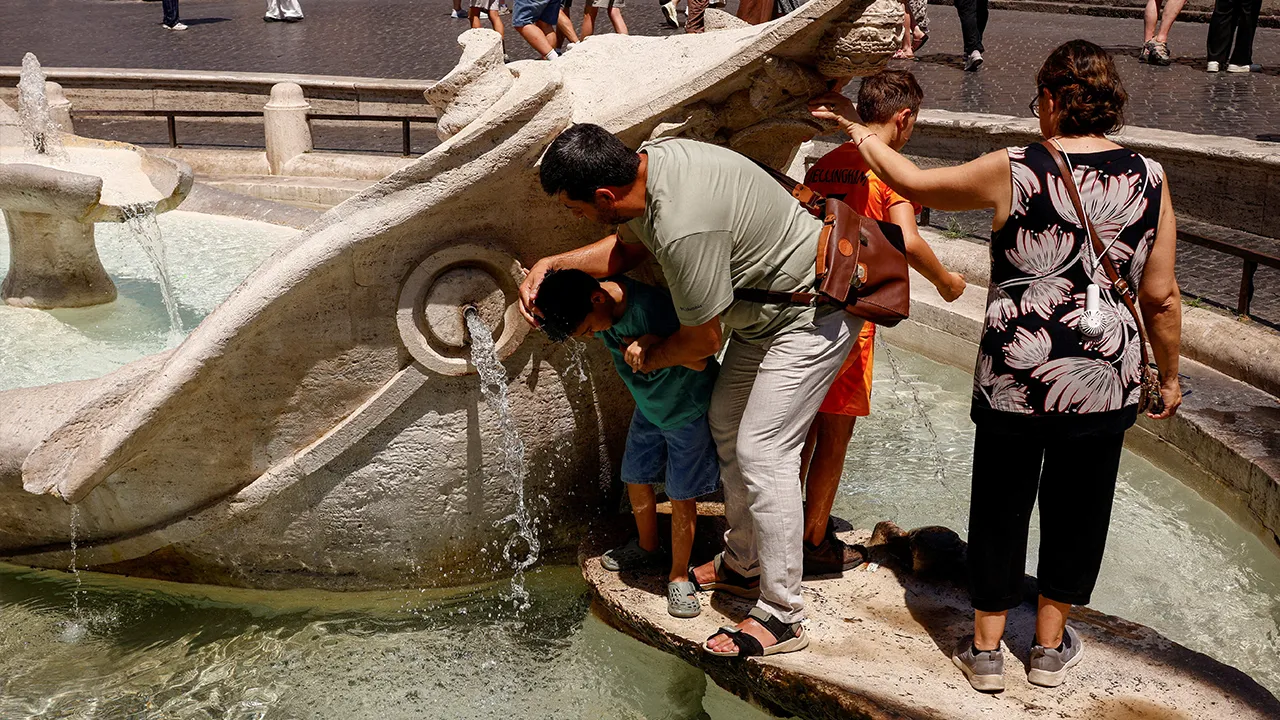 A man cools his child with water from the Fontana della Barcaccia during a heatwave in Rome, Italy, August 6, 2026. REUTERS/