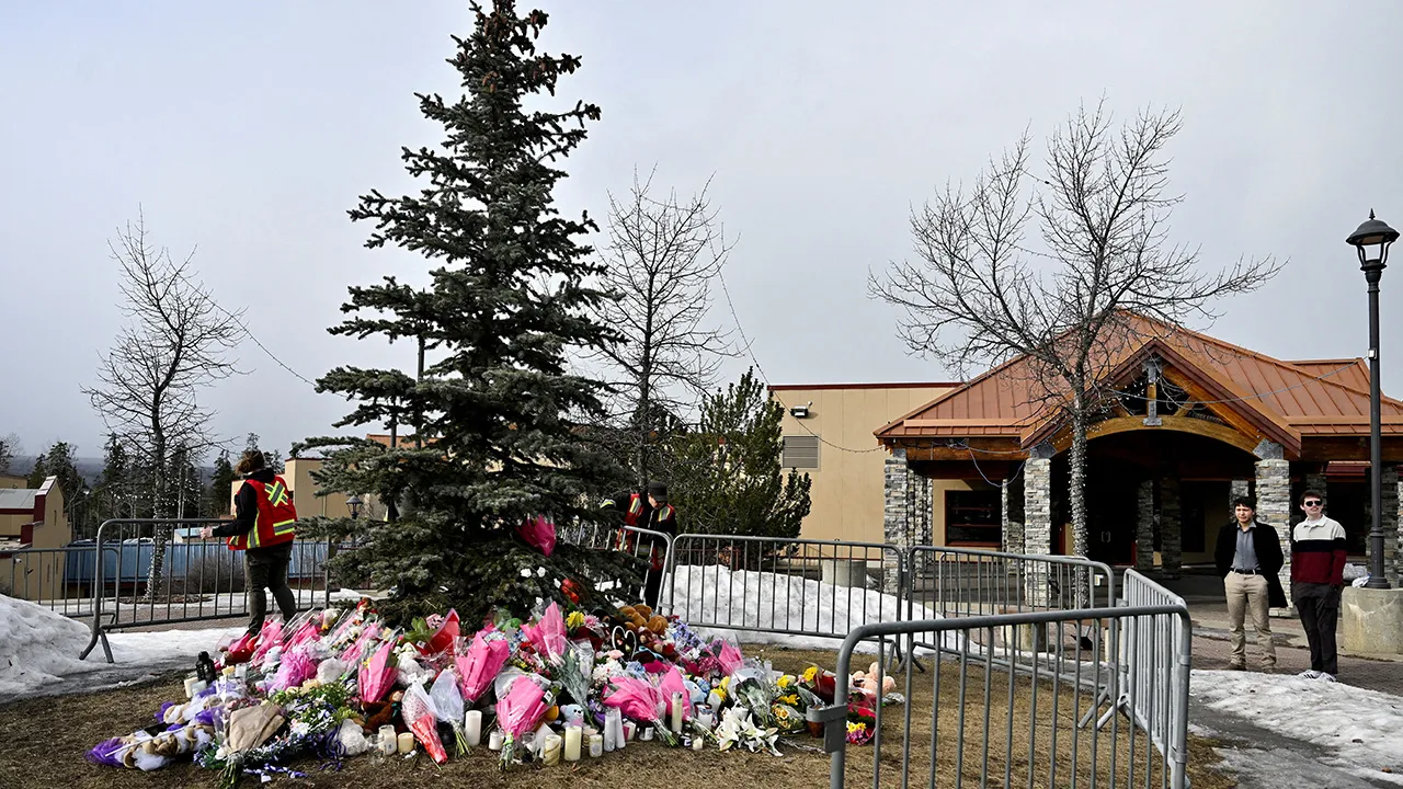 Workers install a fence around a makeshift memorial for the victims two days after a deadly mass shooting took place at a school in the town of Tumbler Ridge, British Columbia, Canada, February 12, 2026. REUTERS