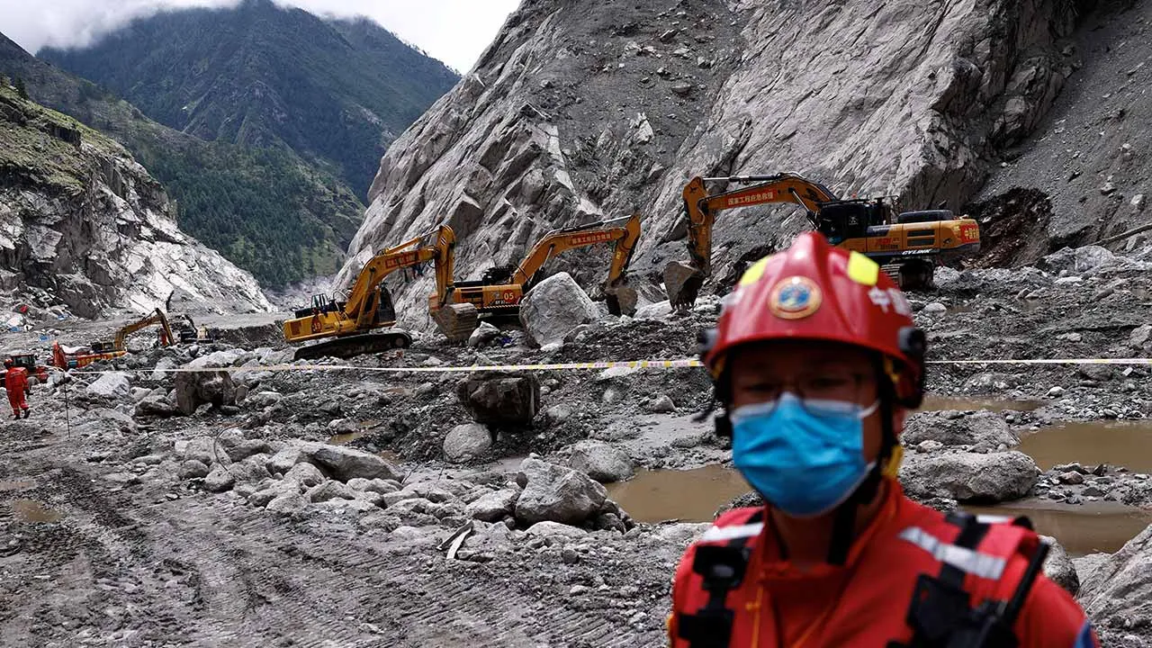 A rescue worker stands near excavators at the core disaster-hit area at Gyirong Port amid rescue efforts following the August 26 mudslide, during an organised media tour in Shigatse, Tibet Autonomous Region, China September 6, 2026. REUTERS/Tingshu Wang/Pool