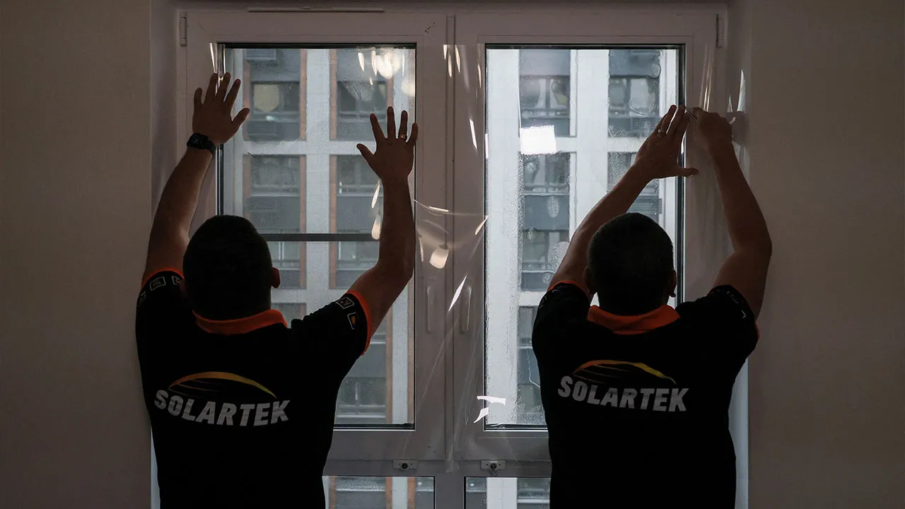 Employees of Russian firm Solartek install shatter-resistant film on a window in an apartment, as demand for blast protection rises following Ukrainian drone strikes during the Russia-Ukraine conflict, in Moscow, Russia, August 26, 2026. REUTERS/Ramil Sitdikov