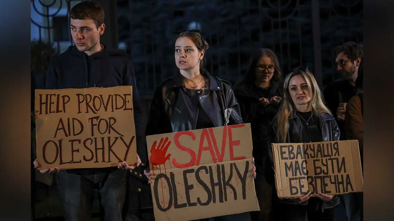 People hold posters as they participate in a rally demanding the establishment of a humanitarian corridor to evacuate Ukrainian civilians from the town of Oleshky in Kherson region, amid Russia's attack on Ukraine, in Kyiv, Ukraine October 6, 2026. REUTERS/Alina Smutko