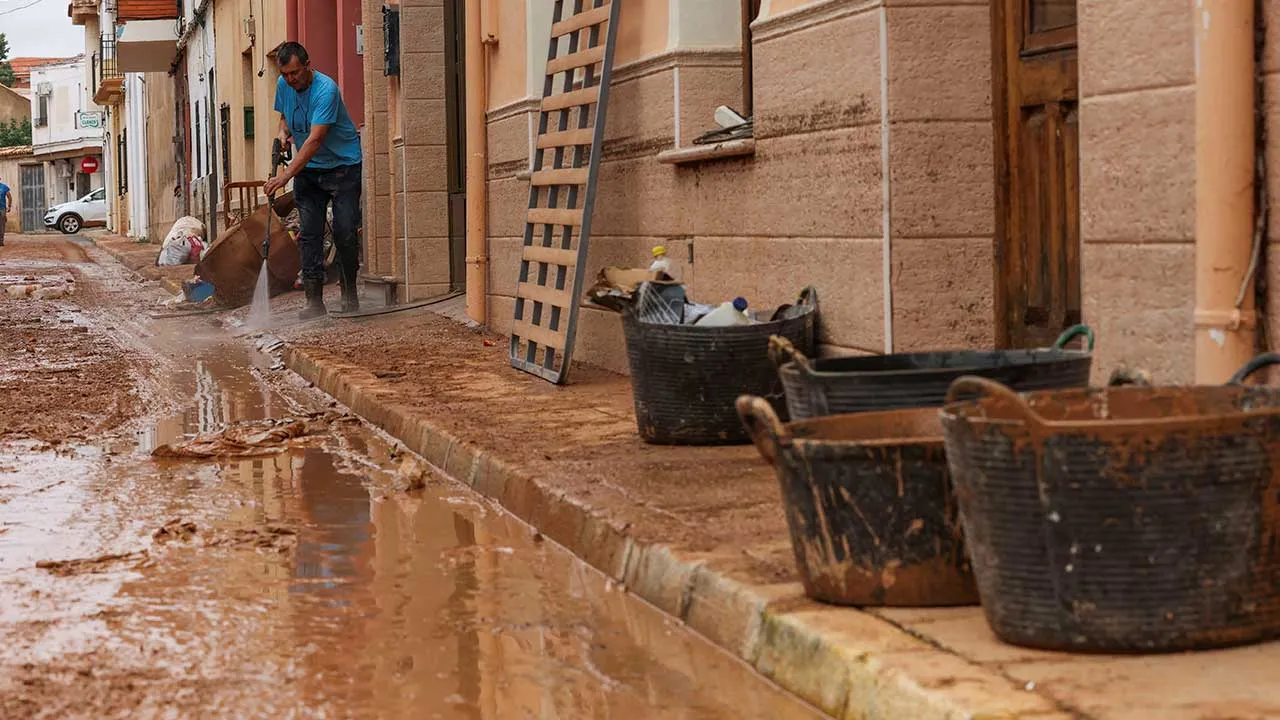 A resident clears a street in the aftermath of flooding caused by heavy rains, in Madrigueras, Spain, October 3, 2026. REUTERS/Eva Manez