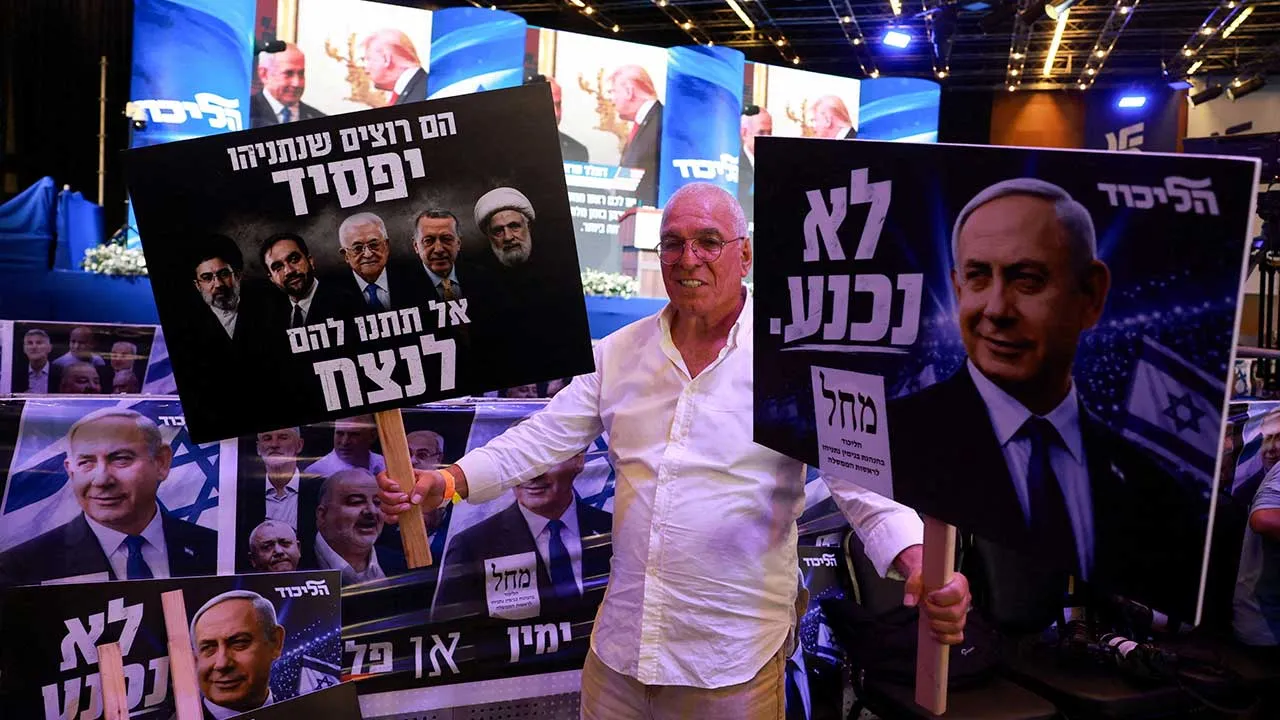A supporter reacts to exit polls holding signs depicting Israeli Prime Minister and Likud party leader Benjamin Netanyahu during Israel's national election, at Likud's election headquarters in Jerusalem, October 27, 2026. REUTERS/Ronen Zvulun TPX IMAGES OF THE DAY