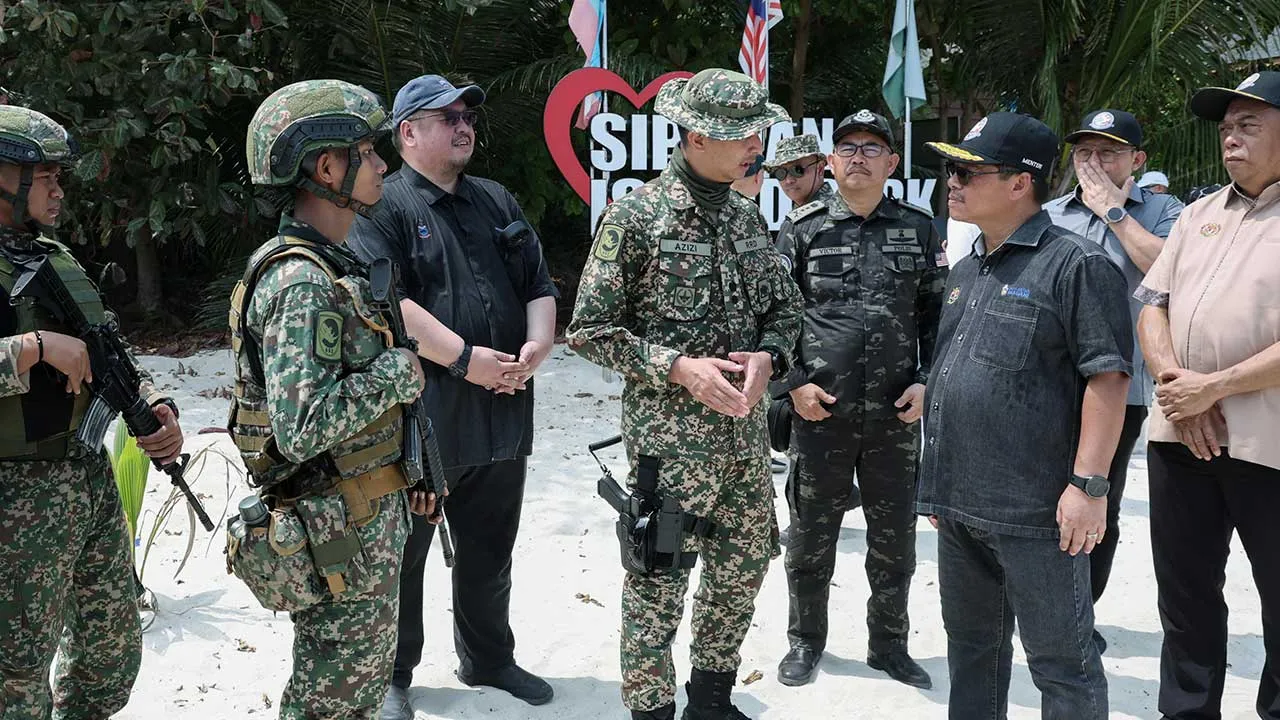 SEMPORNA, 19 Okt " Menteri di Jabatan Perdana Menteri (Sabah dan Sarawak) Datuk Mustapha Sakmud (kanan) beramah mesra dengan anggota tentera yang bertugas di Pulau Sipadan sempena lawatan kerja beliau ke daerah Semporna hari ini.  -- fotoBERNAMA (2026) HAK CIPTA TERPELIHARA