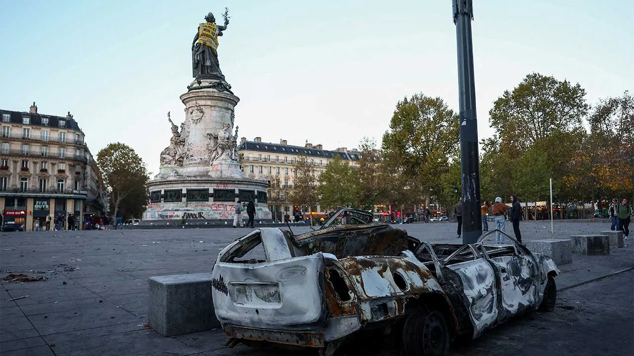 A destroyed car near the Marianne statue at the Place de la Republique, with a yellow vest put on it, the day after clashes during a national day of demonstrations against the cost of living and rising fuel prices, in Paris, France, October 18, 2026. The back of the vest reads: 'In 1961 the police drowns Algerian women'. REUTERS/Abdul Saboor TPX IMAGES OF THE DAY
