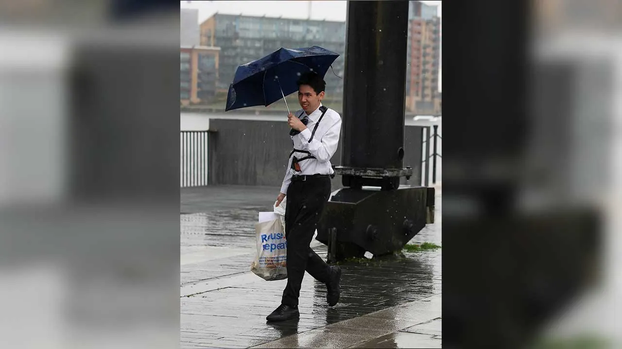A man holding an umbrella walks as Storm Boelo brings wet and windy weather to parts of the UK, in London, Britain, October 24, 2026. REUTERS/Corey Rudy
