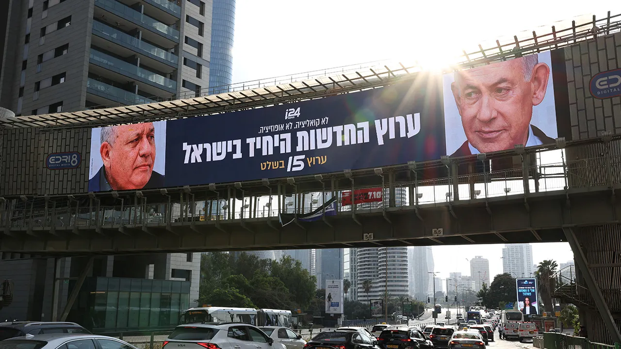 An advert for an Israeli television channel that will broadcast Israel's election coverage features Israeli Prime Minister Benjamin Netanyahu and former Israeli military chief Gadi Eisenkot, leader of the Yashar party, ahead of Israel's national election, on a bridge in Tel Aviv, Israel, October 21, 2026. REUTERS/Ammar Awad