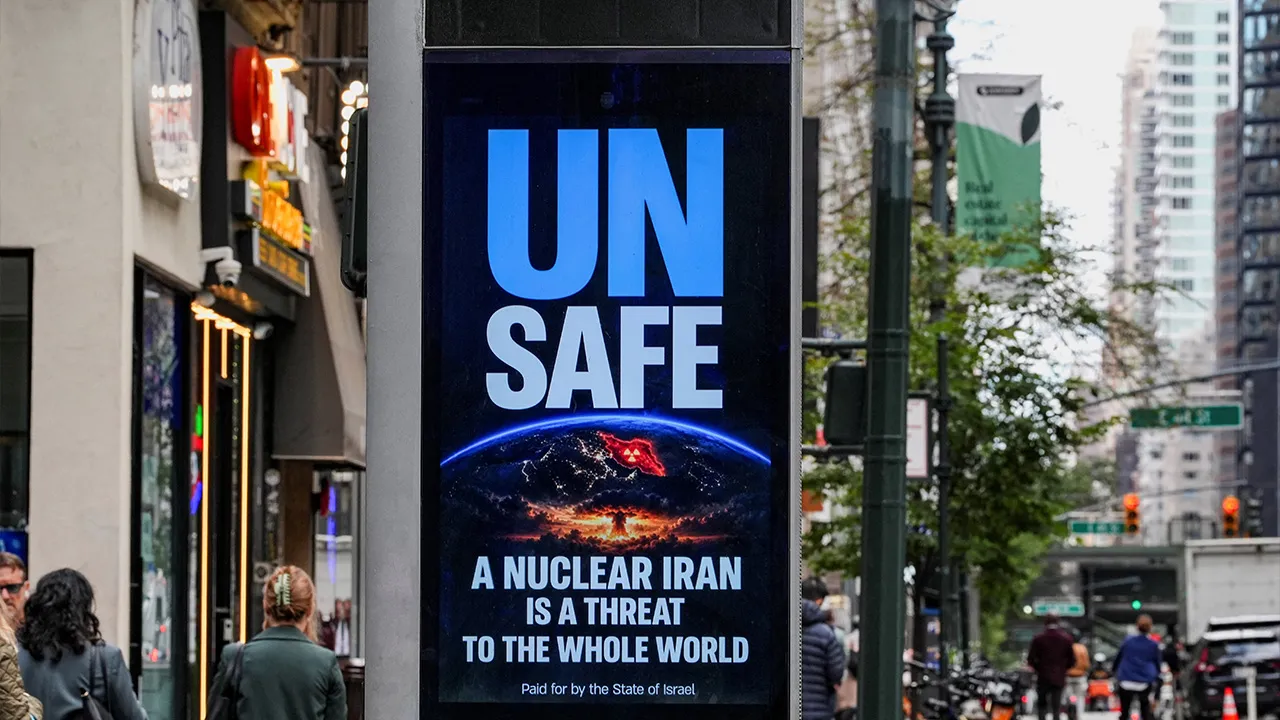 A digital billboard displays a message reading "UN SAFE: A Nuclear Iran Is a Threat to the Whole World" as pedestrians walk along a street during the 81st United Nations General Assembly in New York City, U.S., September 24, 2026. REUTERS/