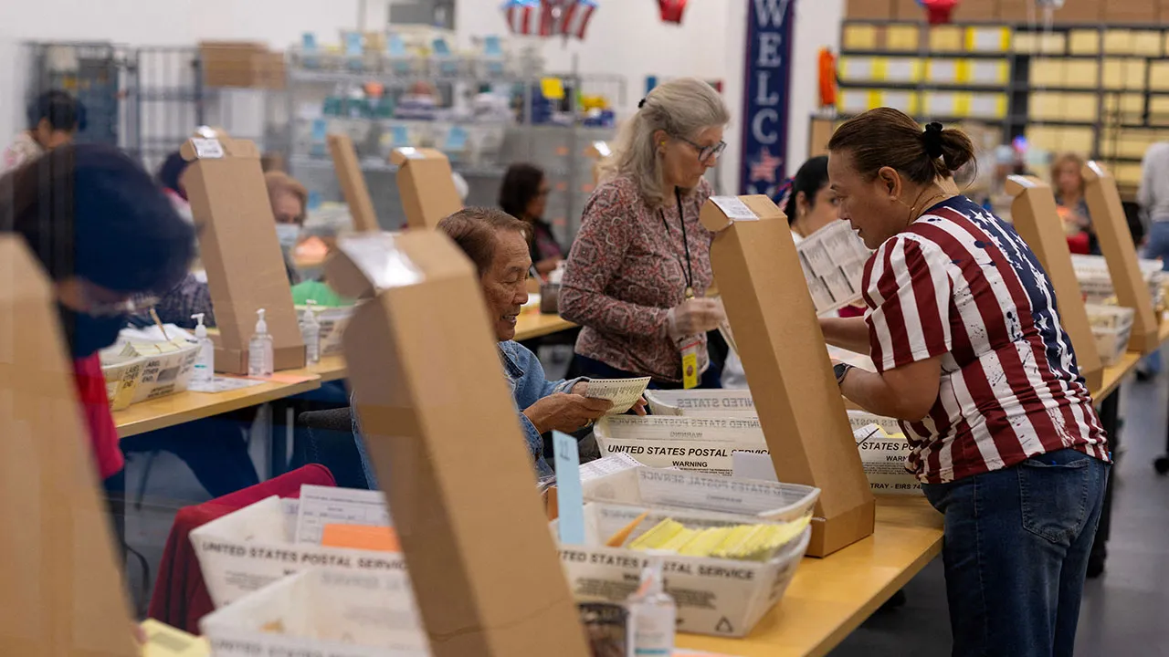 FILE PHOTO: Election workers extract mail-in ballots at the registrar of voters' office during the California primary election in San Diego, California, U.S., June 2, 2026. REUTERS/Mike Blake/File Photo