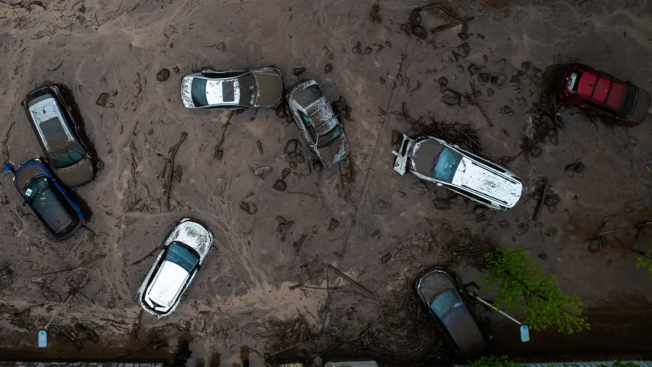 Vehicles are partially inundated in muddy floodwaters after heavy rains caused flash flooding in the Las Condes district of Santiago, Chile, Thursday, Oct. 8, 2026. (AP Photo/Esteban Felix)