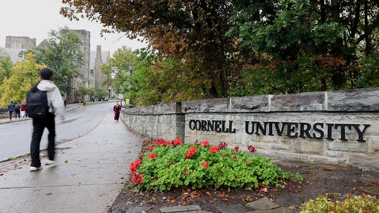 FILE PHOTO: A student walks by a sign at the entrance of Cornell University in Ithaca, New York, US, October 1, 2026. REUTERS/Lauren Petracca/File Photo