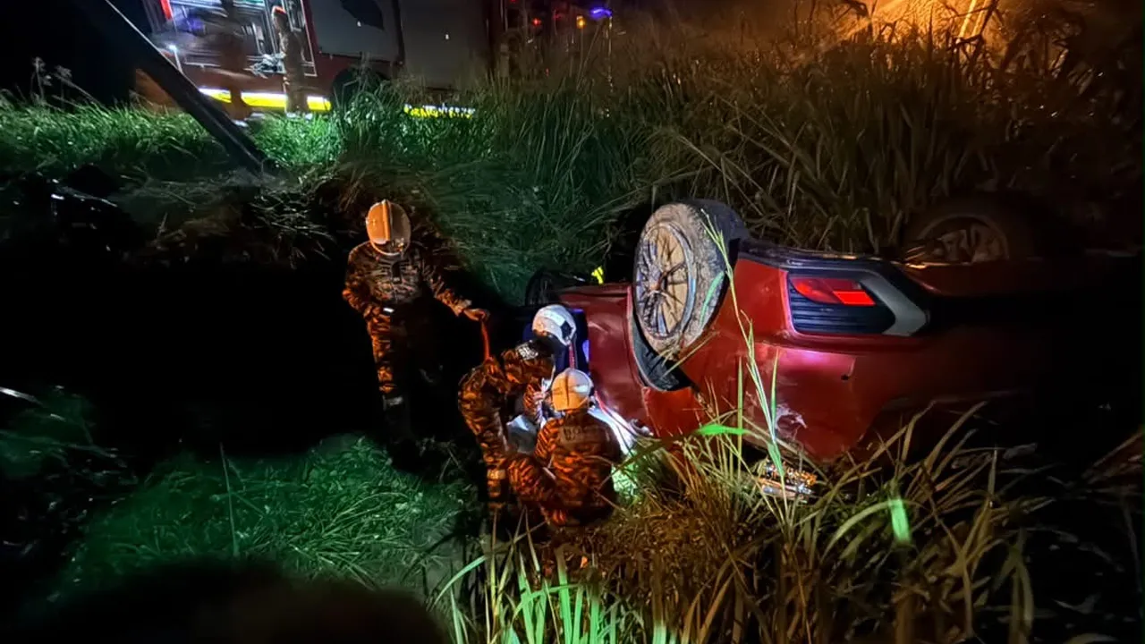 Anggota bomba mengeluarkan pemandu yang parah dalam nahas kereta dan motosikal di Teluk Sareh, Kampung Gajah, awal pagi ini. Foto JBPM Perak