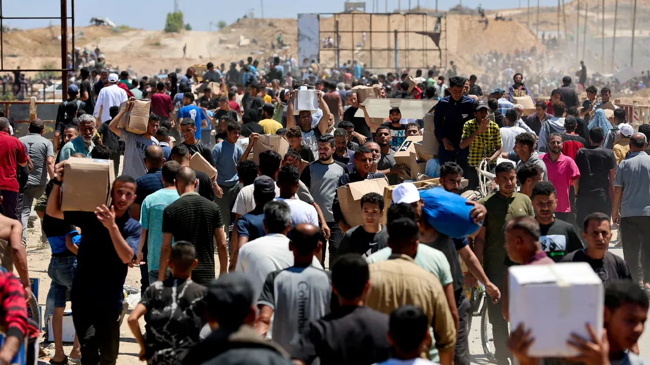 Palestinians carry aid supplies which they received from the U.S.-backed Gaza Humanitarian Foundation, in the central Gaza Strip, May 29, 2025. REUTERS/Ramadan Abed/File Photo
