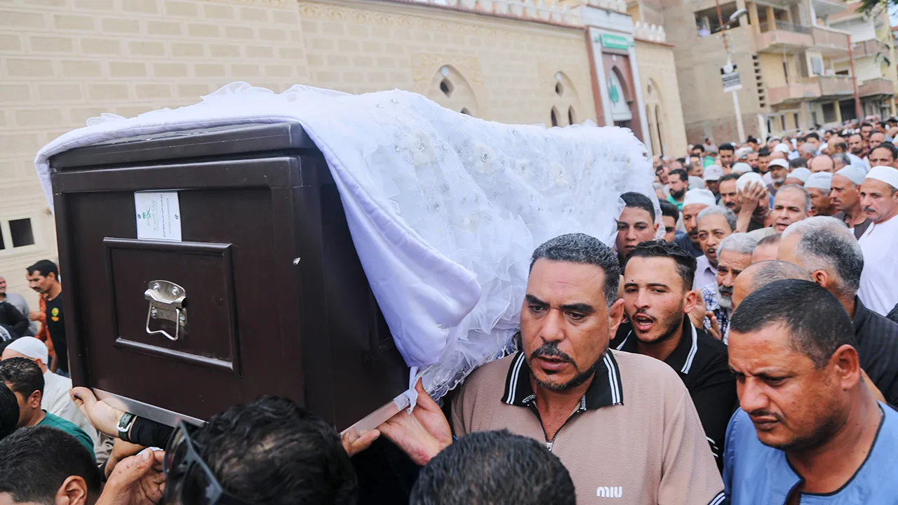 Relatives and neighbors carry the coffin of Azza Ramzi, an Egyptian victim of Saturday's strike on King Khalid International Airport in Riyadh, during his funeral procession in Beheira, Egypt, Tuesday, Oct. 13, 2026. (AP Photo/Mostafa Hassan)