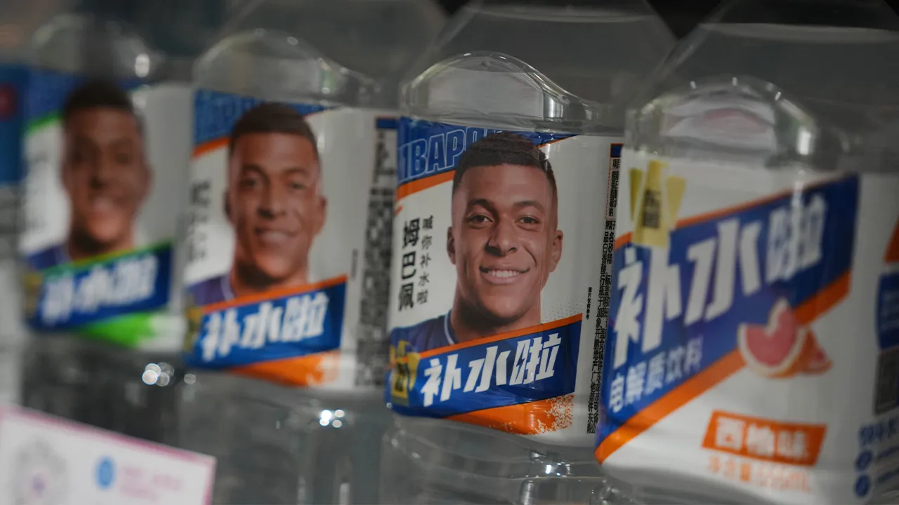 Bottles of electrolyte drink by Dongpeng Beverage Group featuring images of French soccer star Kylian Mbappé are displayed for sale at a supermarket in Beijing, Tuesday, Oct. 27, 2026. (AP Photo/Andy Wong)