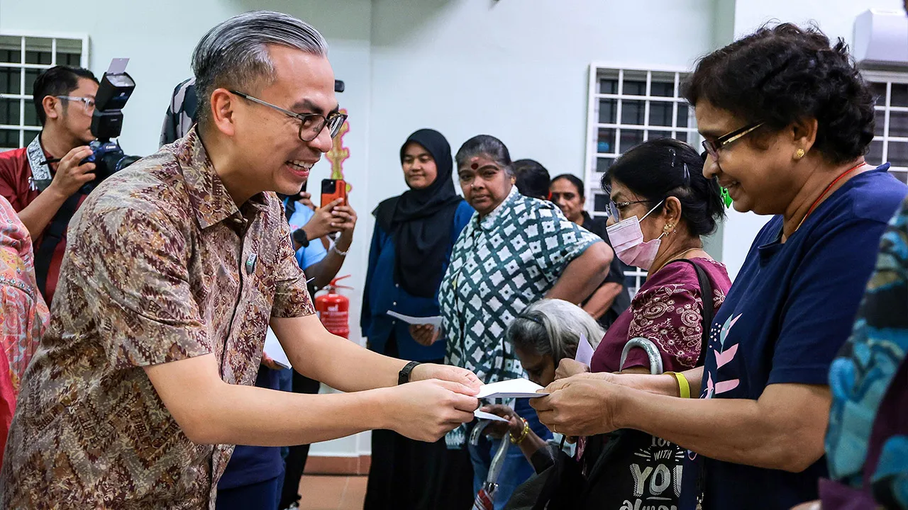 KUALA LUMPUR , 27 Okt -- Menteri Komunikasi Datuk Seri Fahmi Fadzil (kiri) menyampaikan sumbangan kepada kaum India pada Majlis Serahan Sumbangan sempena Perayaan Deepavali kepada masyarakat India Taman Seri Sentosa, hari ini._BERNAMA