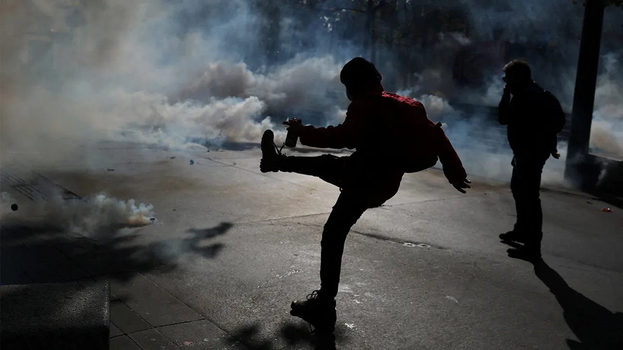 A masked protester attempts to kick a tear gas canister amid clashes with the French riot police at the Place de la Republique during a demonstration against the cost of living and rising fuel prices in Paris as part of nationwide protests called by the "Yellow Vests" movement, joined by French high school and university students, teachers and parents demanding better school conditions and government action, as well as labour unions, workers, farmers and retirees, France, October 17, 2026. REUTERS/Stephanie