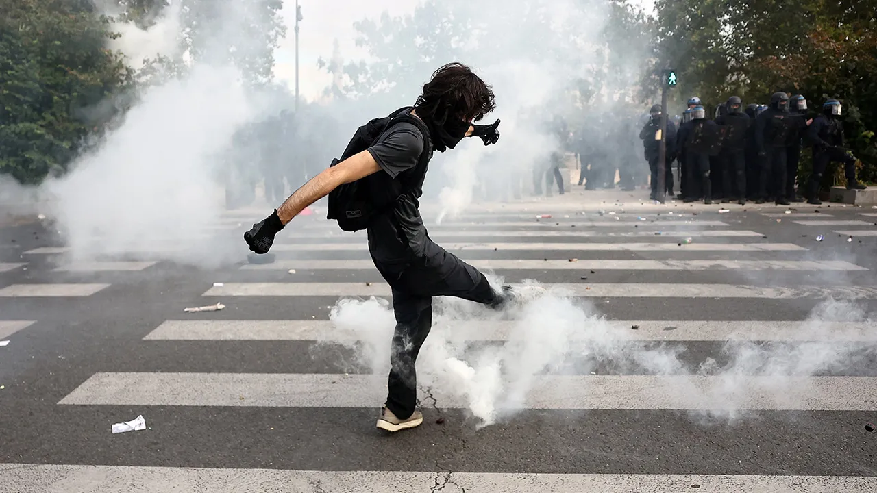 A masked students attempts to kick a tear gas canister amid clashes with French riot police during a demonstration by high school and university students, supported by teachers' union and school parents, in Paris as part of a nationwide day of protests and blockades, voicing anger over overcrowded classrooms, teacher shortages and dilapidated school buildings, which students blame on years of underinvestment, France, October 6, 2026. REUTERS/Abdul Saboor  Preview Download Preview  XML Download XML free to m