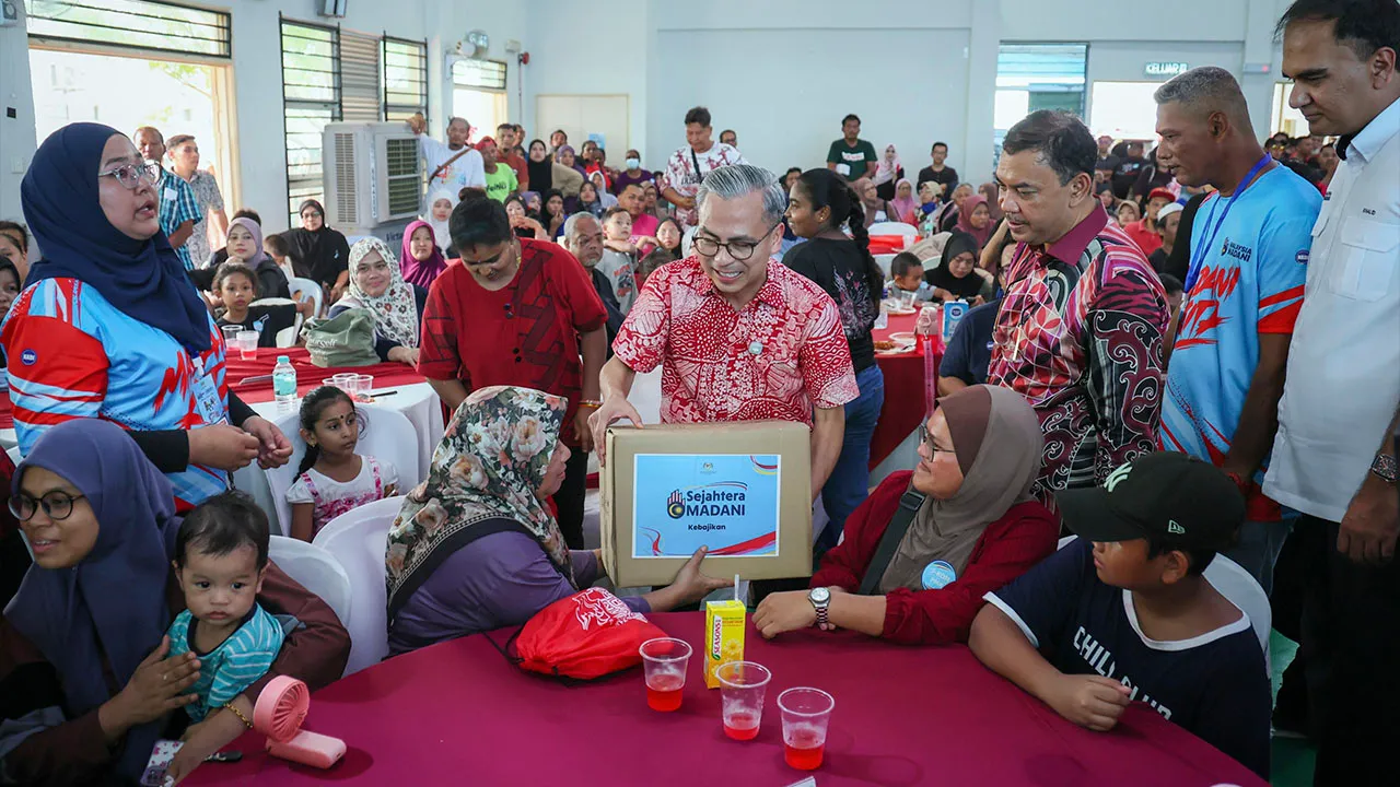 MELAKA, 10 Okt - Menteri Komunikasi Datuk Seri Fahmi Fadzil (tengah) semasa menyampaikan kotak sumbangan kepada seorang penerima pada majlis Perasmian Program MADANI Kita (PMK) Kominiti Paya Rumput di Projek Perumahan Rakyat Krubong, hari ini._BERNAMA